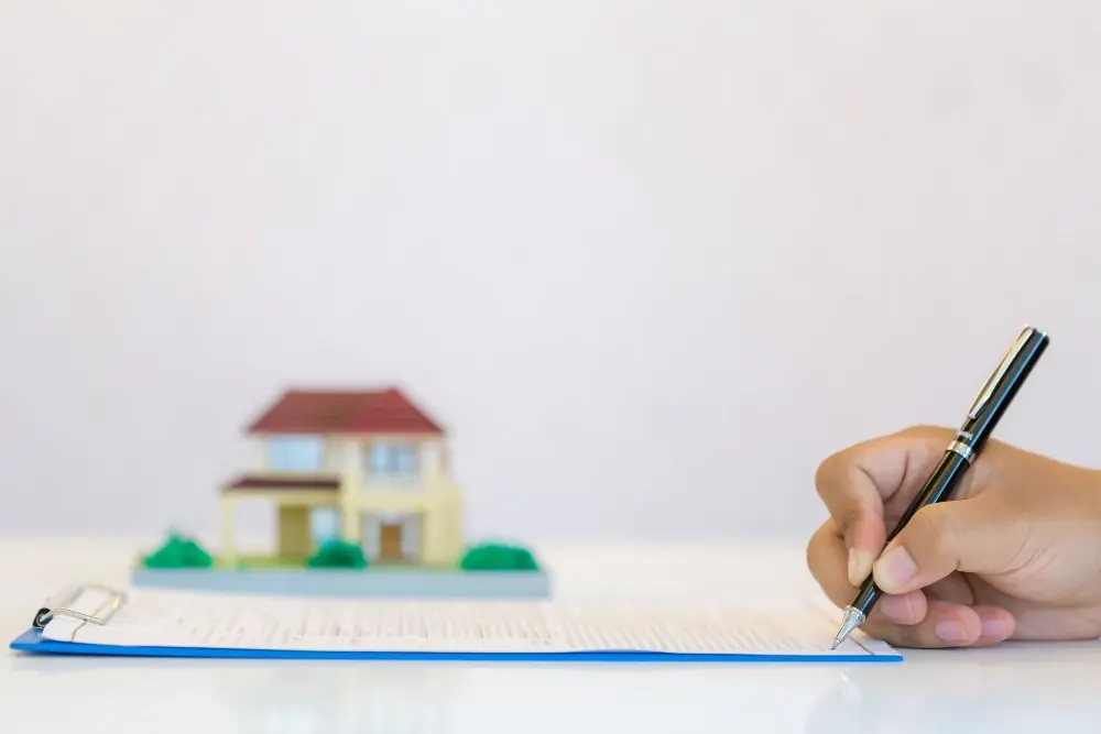 Engineer completing landlord certification paperwork with a property model